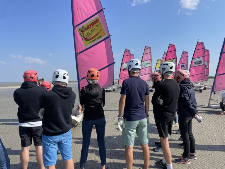 Briefing par des moniteurs de char à voile, diplômés BE, avant de s'élancer sur la plage près de Saint-Malo, bien équipé.